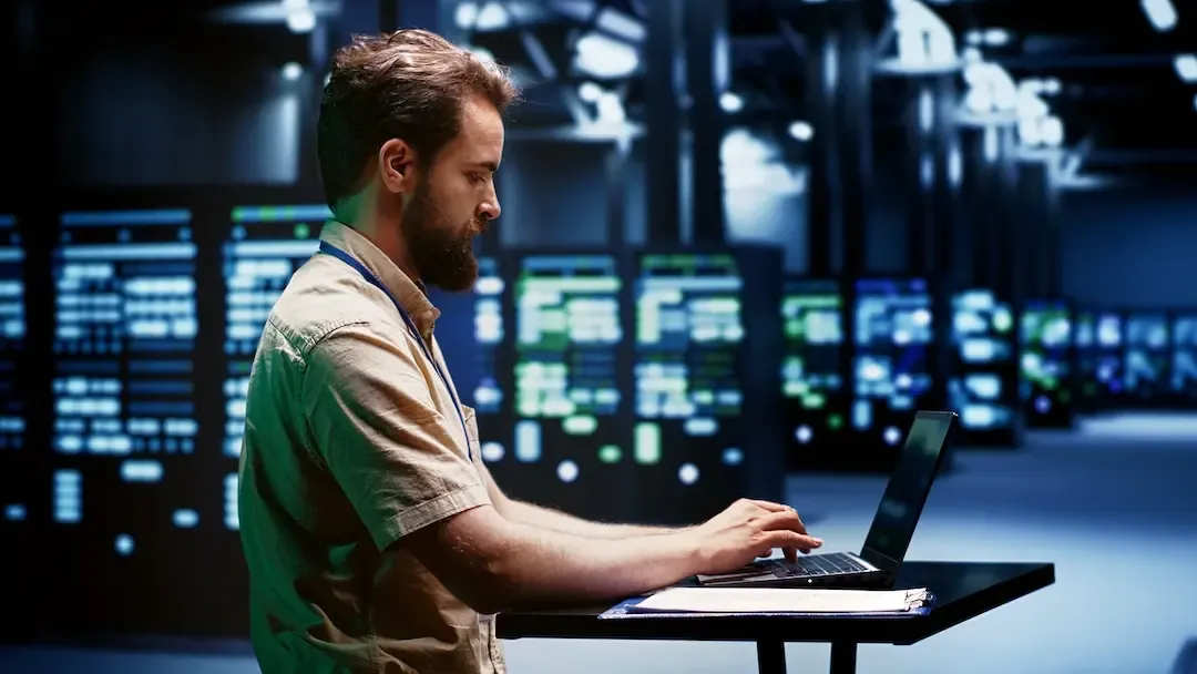 Técnico con una computadora portátil en una sala de servidores